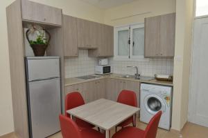 uma cozinha com uma mesa e uma máquina de lavar roupa em Poseidono's Apartment em Pafos