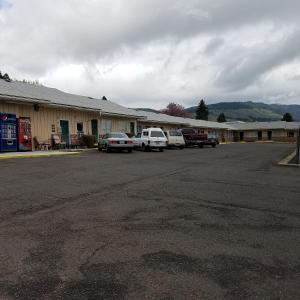 a parking lot with cars parked in front of a motel at Greenwell Motel in La Grande