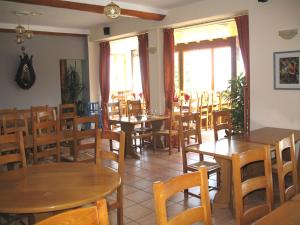 a restaurant with wooden tables and chairs and windows at Les Terrasses du Lac Blanc - Studios & Appartements in Orbey