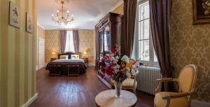 ein Schlafzimmer mit einem Bett und einer Blumenvase auf einem Tisch in der Unterkunft Les Magnolias in Lalinde + 89 Fotos