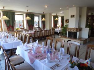 una sala da pranzo con tavoli e sedie bianchi di Hotel & Restaurant Kleinolbersdorf a Chemnitz
