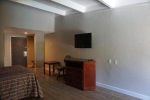 a hotel room with a bed and a television on a wall at Rodeway Inn in Clermont