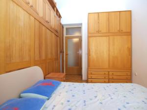 a bedroom with a bed and wooden cabinets at Apartment Old Town in Pula