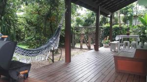 porche con hamaca, mesa y sillas en Casa Aconchegante Paraty, en Paraty