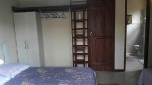 1 dormitorio con cama y estante para libros en Casa Aconchegante Paraty, en Paraty