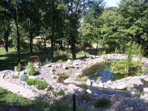 a garden with a pond and rocks and trees at Green Belt Bed & Breakfast in Ames