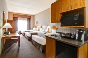 a hotel room with a bedroom and a bed and a kitchen at Canalta Brooks in Brooks