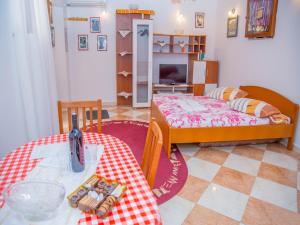 sala de estar con 2 camas, mesa y sillas en Guest House Jeljenic, en Dubrovnik
