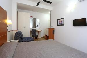 1 dormitorio con cama, mesa y TV en Hotel Corticella, en Bolonia