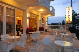ein Restaurant mit Tischen und Stühlen auf einer Terrasse in der Unterkunft Kalipso in Paralia Katerinis