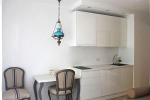 コラレホにあるMagnifico apartamento en las dunas de corralejoの白いキャビネット、テーブルと椅子付きのキッチンが備わります。