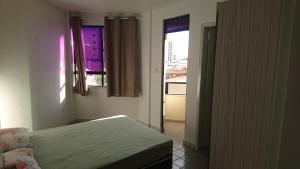a small bedroom with a bed and a window at Apartamento Atalaia Aracaju in Aracaju