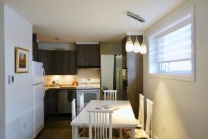 een keuken met een tafel en een witte koelkast bij Résidence Touristique Les Bouleaux in Petit-Saguenay