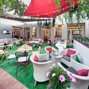 patio ze stołami, krzesłami i kwiatami w obiekcie Hotel Vittoria w mieście Faenza