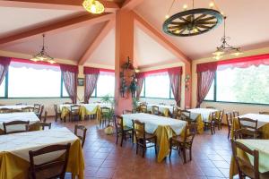 a restaurant with white tables and chairs and windows at Barone Montefeo in Librizzi