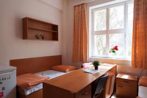 Habitación con escritorio, mesa y ventana. en Roosevelt Hostel, en Praga