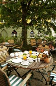 una mesa de madera con comida y bebidas. en Andersen Hotel Birkenwerder, en Birkenwerder