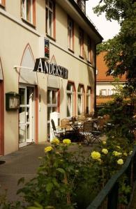 ein Gebäude mit einem Schild an der Seite in der Unterkunft Andersen Hotel Birkenwerder in Birkenwerder