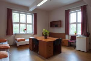 een kantoor met een bureau, stoelen en ramen bij Roosevelt Hostel in Praag