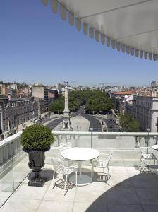 a patio area with a patio table and chairs at Altis Avenida Hotel in Lisbon