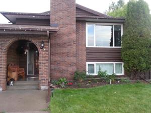 a brick house with a cat sitting on the porch at Newly Renovated Basement Suite! in Lethbridge