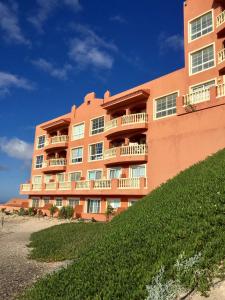 un edificio anaranjado con balcones en el lateral. en Playa Paraiso DolceVita, en Costa Calma