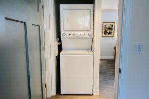 a white refrigerator sitting in a hallway next to a door at Résidence Touristique Les Bouleaux in Petit-Saguenay