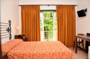 1 dormitorio con cama y ventana grande en Casa do Manequinho Hotel e Restaurante en Piraí