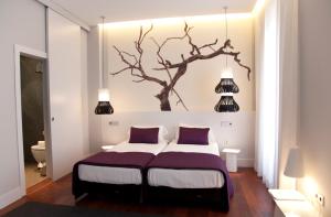 ein Schlafzimmer mit einem Bett mit einem Baum an der Wand in der Unterkunft Khu Hotel in Granada