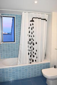 La salle de bains est pourvue d'une baignoire, de toilettes et d'un rideau de douche. dans l'établissement Sky Home Peñiscola, à Peñíscola