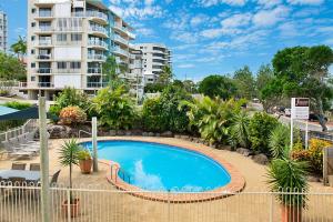 
a large swimming pool in a residential area at Joanne Apartments in Caloundra
