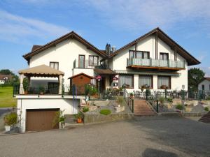 ein großes weißes Haus mit einer Veranda und einer Auffahrt in der Unterkunft Gasthof Sonne in Horriwil
