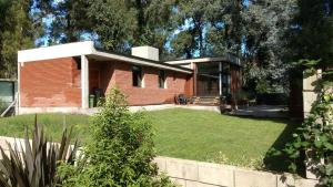a brick house with a lawn in front of it at Casa Huarpes MDP en Bosque Peralta Ramos in Mar del Plata