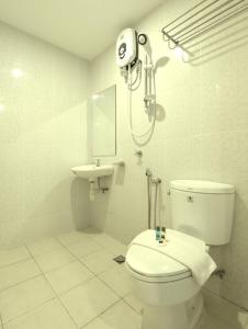 a white bathroom with a toilet and a sink at Hotel Sentral Kuala Terengganu in Kuala Terengganu