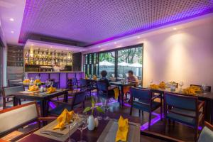 a dining room with tables and chairs and purple lighting at Apsara Residence Hotel in Siem Reap
