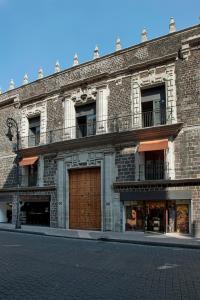 - un grand bâtiment en briques avec un balcon dans une rue dans l'établissement Downtown Beds, à Mexico