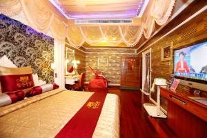 1 dormitorio con 1 cama y TV en una habitación en Wen Sha Bao Motel-Xinying, en Xinying