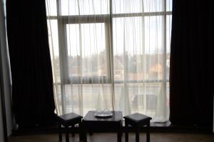 a table and two chairs in front of a large window at Hotel Taverna Pecicana in Pecica Veche