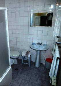 een badkamer met een wastafel, een toilet en een spiegel bij Estrela in Manteigas +27 foto's