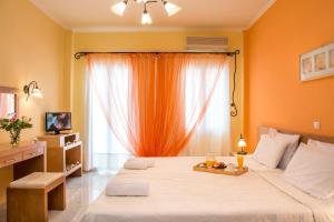 ein Schlafzimmer mit einem großen Bett und einem Fenster in der Unterkunft Kostis Villas in Poros