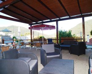 patio z krzesłami, stołami i parasolem w obiekcie Estrela w mieście Manteigas