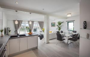 Modern Apartman Pjero في ماكارسكا: مطبخ وغرفة معيشة مع طاولة وكراسي