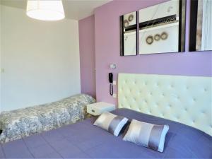 a bedroom with a bed with a purple wall at Hôtel Le Châtelet logis in Saint-Paul-de-Fenouillet