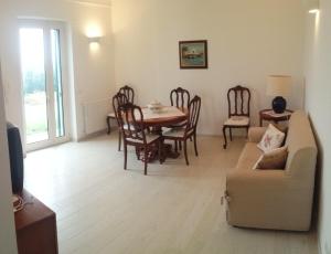 a living room with a table and chairs and a couch at Appartamento Giardinelli - Giulia in Fasano