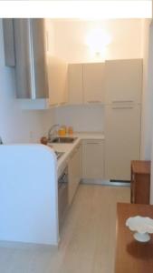 a white kitchen with a sink and a stove at Appartamento Giardinelli - Giulia in Fasano