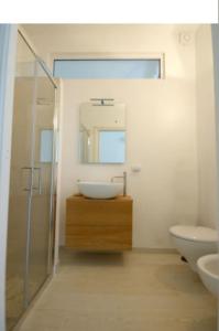a bathroom with a sink and a toilet and a mirror at Appartamento Giardinelli - Giulia in Fasano