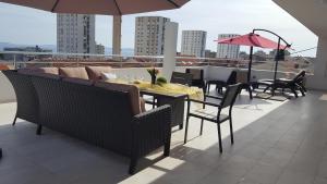 a balcony with a table and chairs and an umbrella at Three Roses in Split