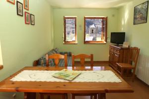 sala de estar con mesa de madera y sillas en Casa Rural Hortal, en Barruera