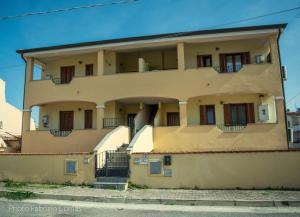an apartment building with stairs in front of it at La Rosa Affittacamere in La Caletta +22 photos