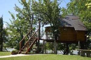 une cabane dans les arbres avec un escalier menant à celle-ci dans l'établissement Holiday Home Kućica Na Drvetu, à Banja Koviljača